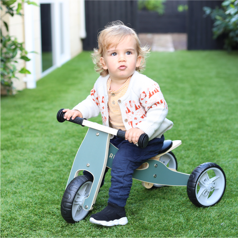 Child on wooden balance bike