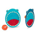 Introducing the Battat B. Shark Velcro Ball Catcher by Battat – a fun and exciting children's toss and catch game. It features two shark-themed paddles with wide open mouths designed to enhance hand-eye coordination. The blue paddles come equipped with handles on the back, and an orange ball with a smiley face is included, positioned to the left of the paddles. This game is perfect for an exciting outdoor playset!