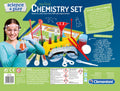 A vibrant packaging for the "Clementoni Science & Play - LAB My First Chemistry Set" by Clementoni. The kit features safety goggles, test tubes, pipettes, a funnel, a spatula, and other contemporary scientific tools. A young girl sporting safety goggles is pictured on the left. Text on the box emphasizes fun and safe chemistry experiments in a modern chemistry laboratory setting.