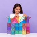 Girl playing with colorful magnetic building blocks against a purple background