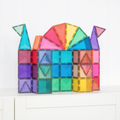 Colorful magnetic building blocks arranged to resemble a castle on a white surface.
