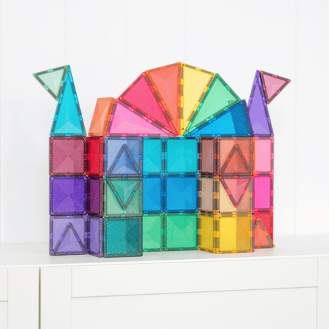 Colorful magnetic building blocks arranged to resemble a castle on a white surface.
