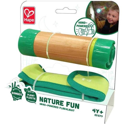The image shows the HAPE Hand-Powered Flashlight, designed for eco-friendly explorers ages 4 and up. This flashlight features a bamboo body with green plastic ends and comes in eco-friendly packaging. The package displays a child using the flashlight and highlights its plant-based plastic composition.