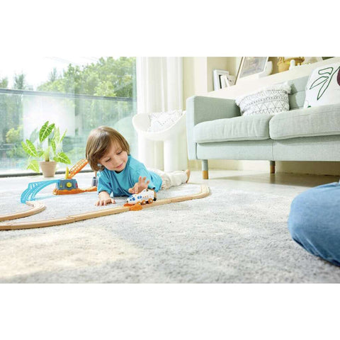 Child playing with the Hape Dual-Mode Space Shuttle on a wooden railway track set