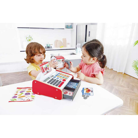 Child playing shop with the Hape Beep n Buy Cash Register