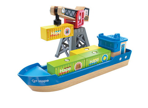 The Hape Cargo Ship & Crane, crafted from wood by Hape, features a blue hull and a magnetic crane for loading yellow and green containers adorned with the Hape logo. The ship also includes a small cabin at the stern, making it a perfect addition to any Hape railway set.