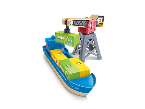 The Hape Cargo Ship & Crane toy set by Hape includes a blue cargo ship loaded with multicolored wooden blocks, one of which displays the word "Hape." The set also features a red and gray magnetic crane for easy loading and unloading. The ship, marked with the code "H-001" on its side, is designed to perfectly complement other Hape railway sets.