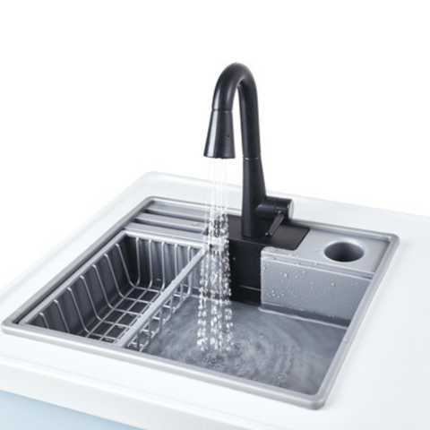 The Hape Deluxe Kitchen with Running Water shown from an angle, with the stovetop, oven and cupboard storage