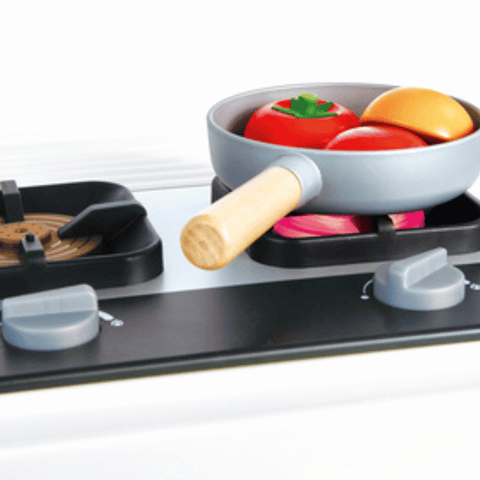 The light-up stovetop of the Hape Deluxe Kitchen with Running Water, which glows and plays cooking sounds during pretend play