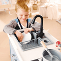 Cihld playing with the Hape Deluxe Kitchen with Running Water 