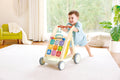 Child taking first steps with the Hape Grow-With-Me Push Walker