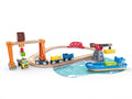 Introducing the Hape Lift & Load Harbour Set: A vibrant toy train set on wooden tracks, complete with a bridge, a crane lifting a container, and a blue cargo ship with containers on a water-themed mat. This engaging Hape railway set includes small vehicles and cargo pieces for imaginative play.