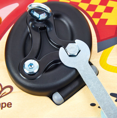 Close-up of a black metal clamp with screws and a wrench on a colorful background