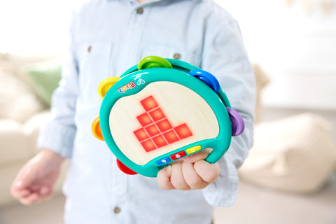 Child playing the Hape Pixelz Shake & Tap Tambourine