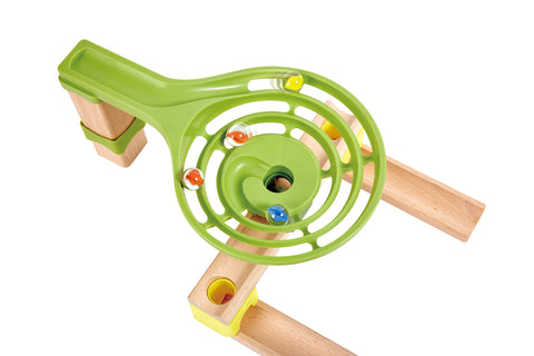 Close-up of the green spiral funnel piece with marbles spinning through the Hape Dino Adventure Run