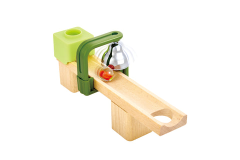 Close-up of a wooden track section with a marble rolling past a chiming bell attachment