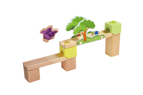 Wooden track section with a pterodactyl figure and dinosaur-themed track panel featuring a house and marble