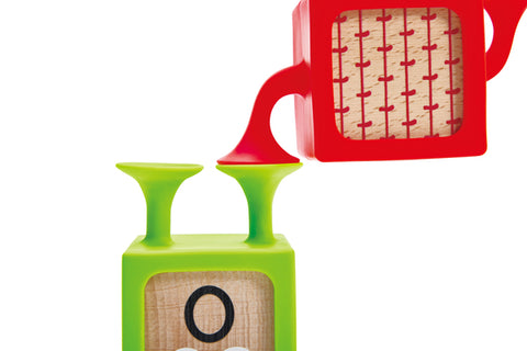 Baby grasping a Hape Suction & Sensory Block