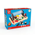Packaged Hape Sushi Time toy set depicting a variety of sushi pieces, chopsticks, a tray, and soy sauce, designed for children.