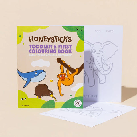 Honeysticks Toddler's First Colouring Book - Endangered Animals Adventure standing beside an open page showing an elephant outline with age and date fields