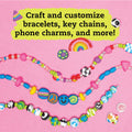 A vibrant display showcases the assortment of handcrafted bracelets against a pink background. These bracelets from "Klutz The Ultimate Clay Bead Book" by KLUTZ feature polymer clay beads shaped like peace signs, smiley faces, soccer balls, and marbled patterns, allowing for unique customization. A yellow text box at the top invites creativity: "Craft and customize bracelets, key chains, phone charms, and more!