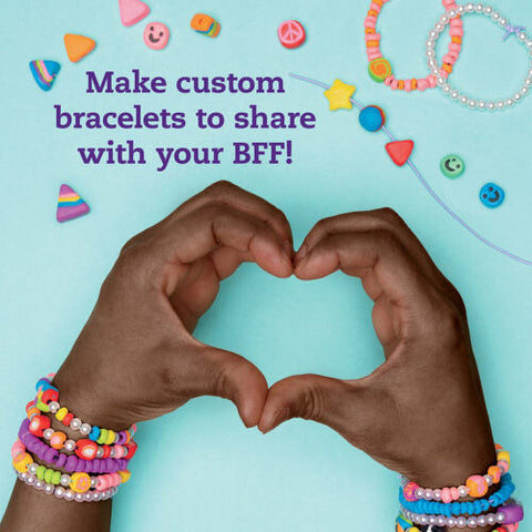 Two hands, adorned with colorful beaded bracelets, form a heart shape against a light blue background. Various bracelet-making beads and tools from "Klutz The Ultimate Clay Bead Book" by KLUTZ surround the text "Make custom bracelets to share with your BFF!" in purple font.