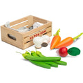 A wooden crate labeled "Le Toy Van Harvest Vegetables" contains educational toy vegetables made of sustainable wood. The fresh veggies include two carrots with green tops, two peas in a pod, two white mushrooms with brown stems, and a red radish with green leaves.