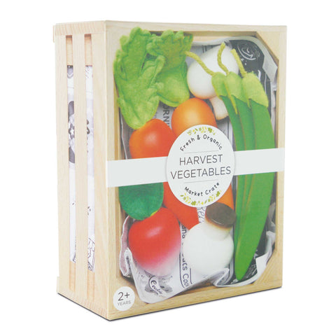 A wooden crate from Le Toy Van Harvest Vegetables collection, crafted from sustainable wood, contains a selection of toy vegetables including a tomato, lettuce, carrots, green beans, and white onions. The label on the front reads "Fresh & Organic Harvest Vegetables Market Crate." Suitable for children aged 2 years and older, this LE TOY VAN educational toy promotes learning through play.