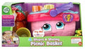 Image of the Leapfrog Shapes & Sharing Picnic Basket toy. The package features a pink basket with a smiling face, as well as colorful plastic food items and tableware. The box emphasizes interactive elements such as a talking picnic set and educational learning songs for children. Suitable for ages 6 months and up.