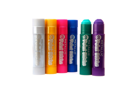 A row of six Little Brian Paint Sticks Metallic, in different colors: silver, orange, pink, blue, green, and purple, all standing upright. Each child-friendly stick is labeled "Little Brian METALLIC Paint Sticks" with a small logo above the text. The background is plain white.