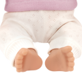 Close-up of a Lullababy doll's legs and feet wearing white pants and a pink top.