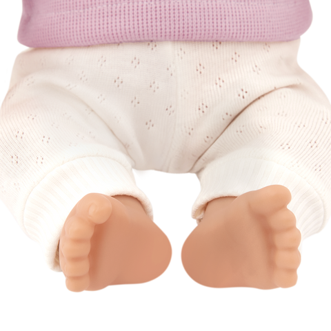 Close-up of a Lullababy doll's legs and feet wearing white pants and a pink top.