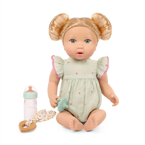Lullababy doll with blonde hair in pigtails, wearing a light green outfit, accompanied by a bottle and blanket on a white background.