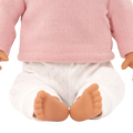 Close-up of a Lullababy doll wearing a pink sweater and white pants with a white background