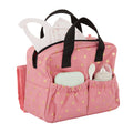 Lullababy Doll pink diaper bag with black handles and star pattern, containing baby items on a white background.