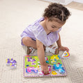 Child sitting on the floor playing with the Melissa & Doug Unicorn Chunky Puzzle, with the rainbow and purple unicorn pieces lifted out beside the board
