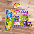 Flat lay of the Melissa & Doug Unicorn Chunky Puzzle with the rainbow piece lifted out above the board, showing all five unicorns in place