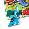 Close-up of two blue long-necked dinosaur pieces from the Melissa & Doug Chunky Dinosaur Puzzle standing beside the puzzle board