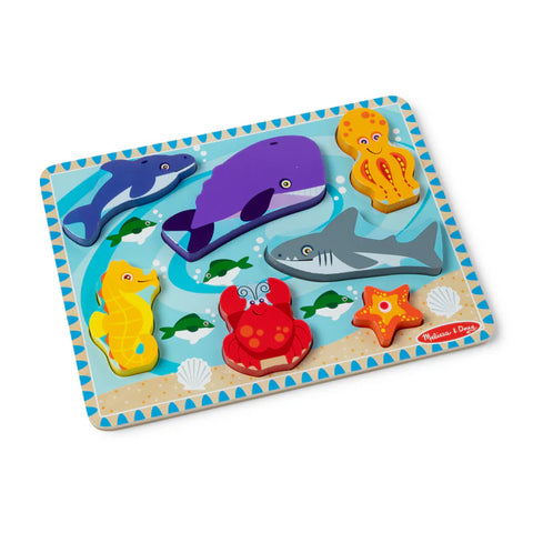 Melissa & Doug Sea Life Chunky Puzzle fully assembled, showing all seven pieces - dolphin, whale, octopus, shark, seahorse, crab and starfish - in the ocean scene