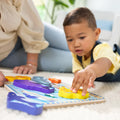 Close-up of a toddler placing the yellow seahorse piece into the Melissa & Doug Sea Life Chunky Puzzle board