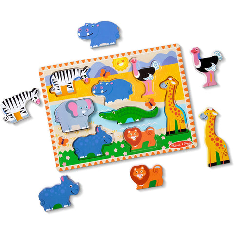 The Melissa & Doug Safari Chunky Puzzle - 8 Pieces, a product by Melissa & Doug, features colorful wooden pieces shaped like wild animals such as a zebra, elephant, crocodile, hippo, lion, ostrich, and giraffe. Some pieces are detached and scattered around the board. The puzzle illustrates a sunny mountainous landscape perfect for developing fine motor skills in children.