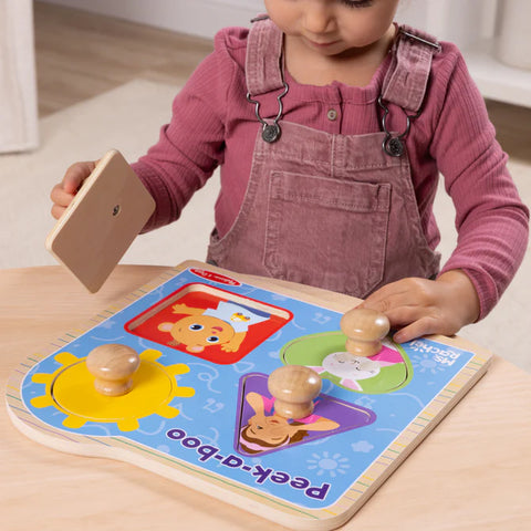 Child playing with a wooden toy puzzle on a table