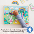 Child playing with a colorful puzzle featuring a van, rabbit, and other elements on a white background.