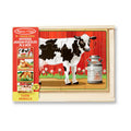 Melissa & Doug Farm Puzzles in a Box packaging, showing the cow jigsaw puzzle assembled in its wooden tray with previews of the horse, hen and chick, and pig puzzles