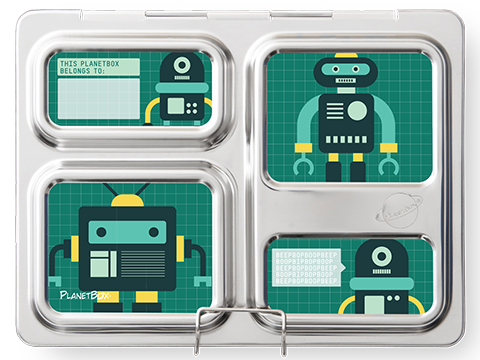 A stainless steel lunchbox with compartments, featuring a robot-themed design and customizable CAMELBAK PlanetBox Launch magnet. The compartments display illustrations of robots with green grid backgrounds and text areas, including "THIS PLANETBOX BELONGS TO:" for personalization. The PlanetBox logo is seen in the corner.