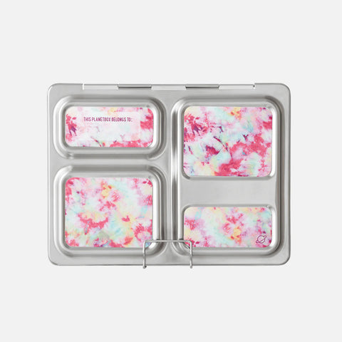 The CAMELBAK PlanetBox Launch Magnet is a stainless steel customizable lunchbox with five compartments, each featuring removable inserts in a vibrant tie-dye pattern of pink, blue, and white. It includes accessories like lunchbox magnets and a top left compartment for personalizing with your name.