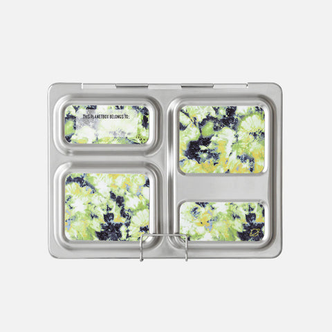 A metallic lunch tray featuring compartments filled with food in colorful, abstract patterns. The top left corner reads "THIS IS A PLANETBOX COLDKIT." The overall design, enhanced with customizable CAMELBAK Planetbox Launch Magnets, has a vibrant, marbled blend of green, yellow, black, and white colors.