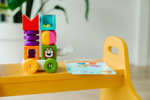 Colorful toy stacker on a yellow tray with a blurred background