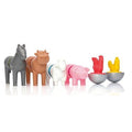 The SmartMax My First Farm Friends (16 pc) collection from SmartMax includes a grey horse, brown cow, white sheep, pink pig, and a set of egg holders shaped like half shells with red and yellow chickens sitting on top. The animals, made from colorful plastic, are all standing in a line.