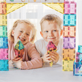 Two children smiling behind a doorway built from pastel TileTek magnetic tiles
